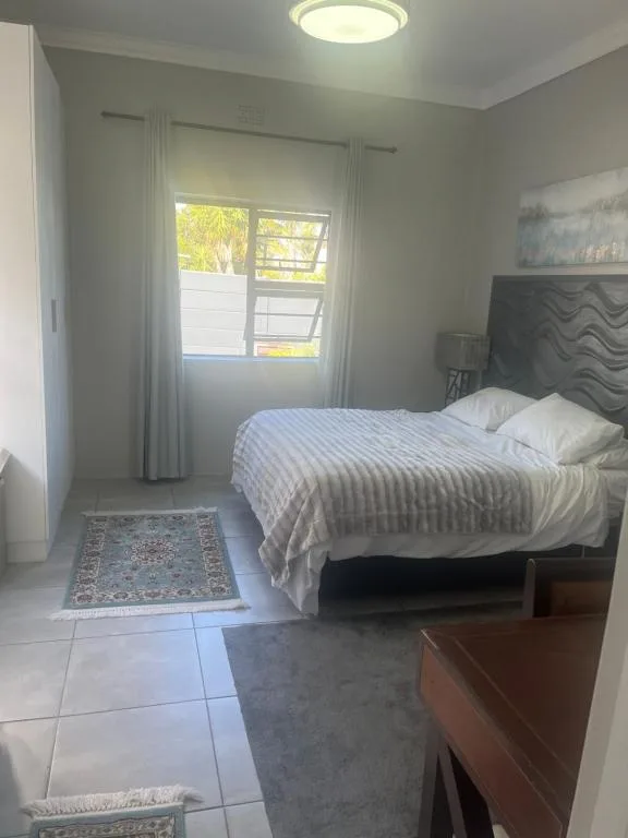 Bright bedroom with queen bed, large window, and natural light