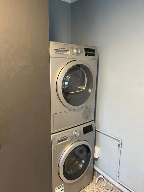 Stacked washing machine and dryer units in compact laundry space