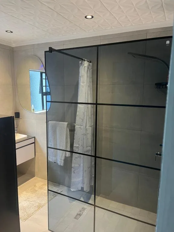 Modern bathroom with frameless glass shower enclosure and sleek vanity