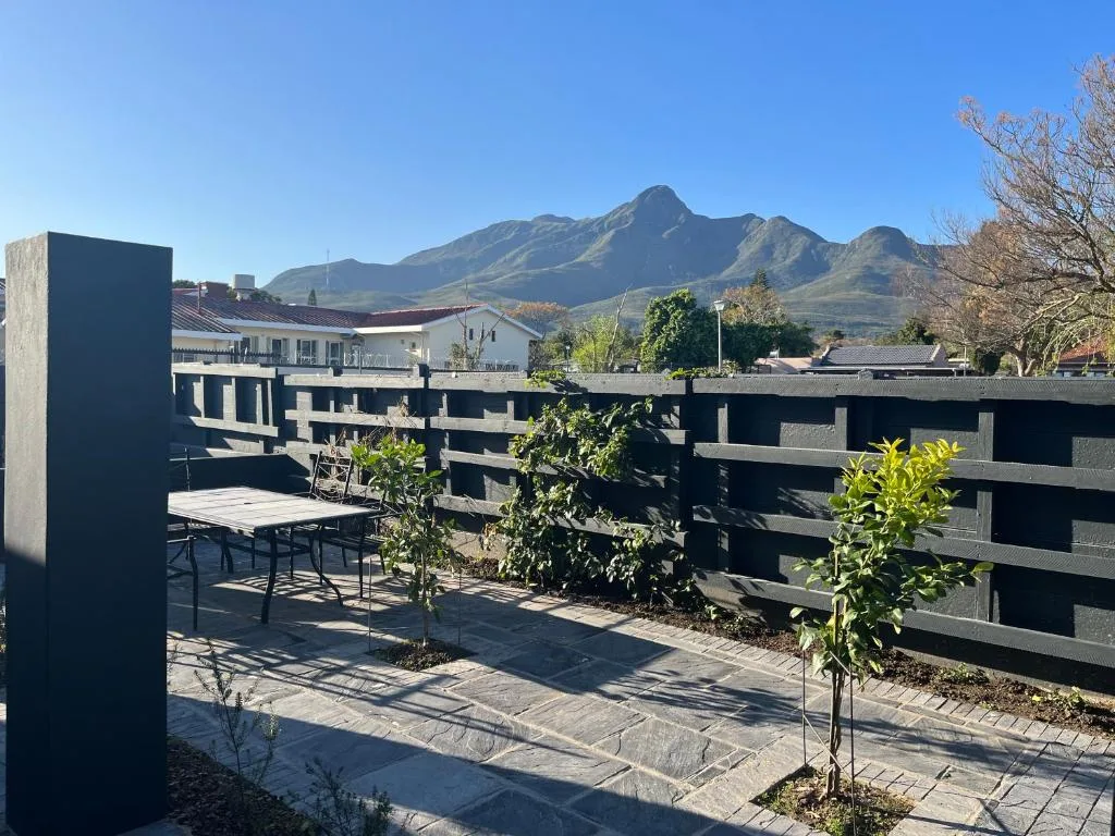 Modern patio with dining table and mountain views beyond black railings