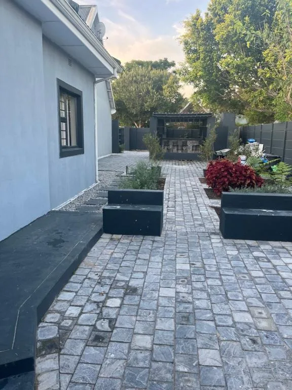 Paved courtyard with planters, seating areas, and modern black structures
