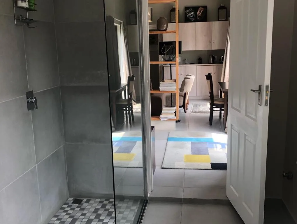 Modern bathroom with frameless glass shower enclosure and geometric floor tiles