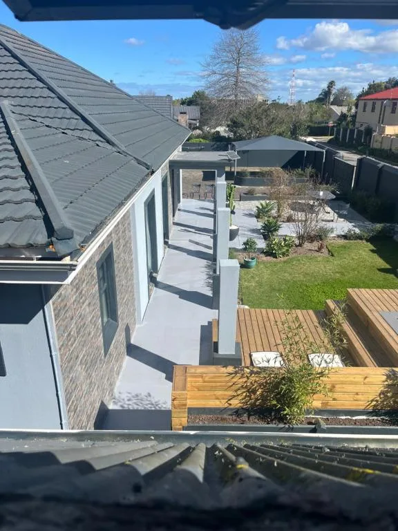 Modern wooden deck with garden and contemporary house exterior beyond