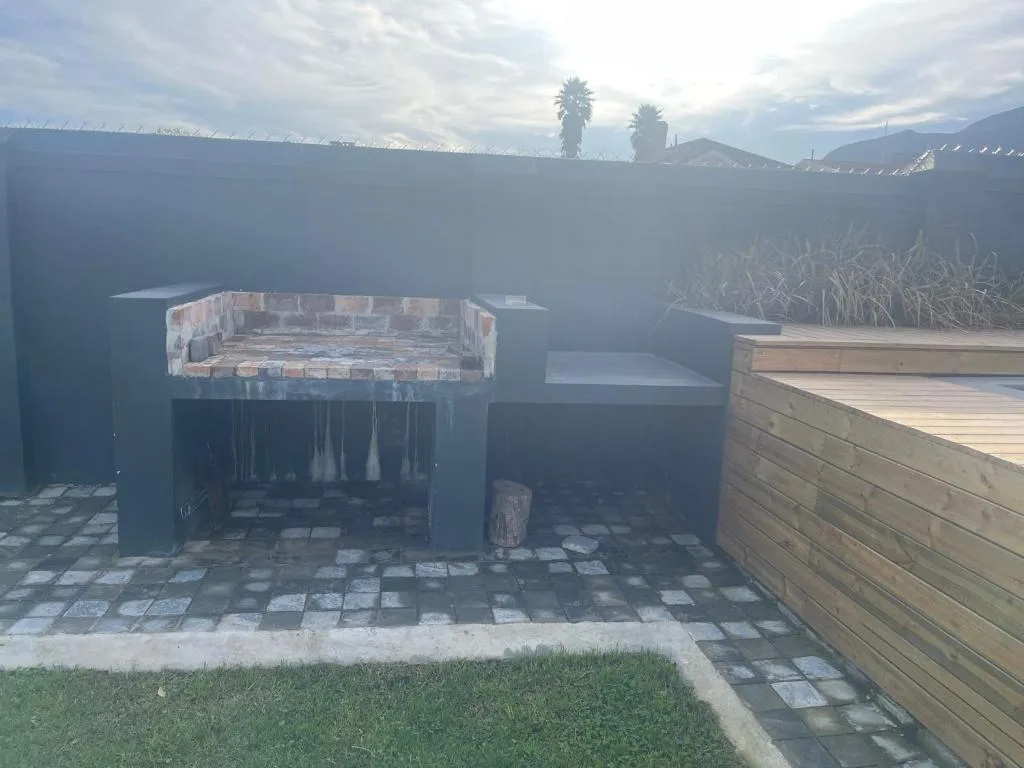 Outdoor braai area with brick fireplace and mountain views beyond