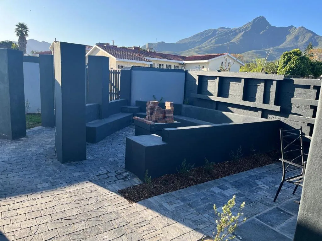 Modern paved outdoor patio with firepit and mountain views in background