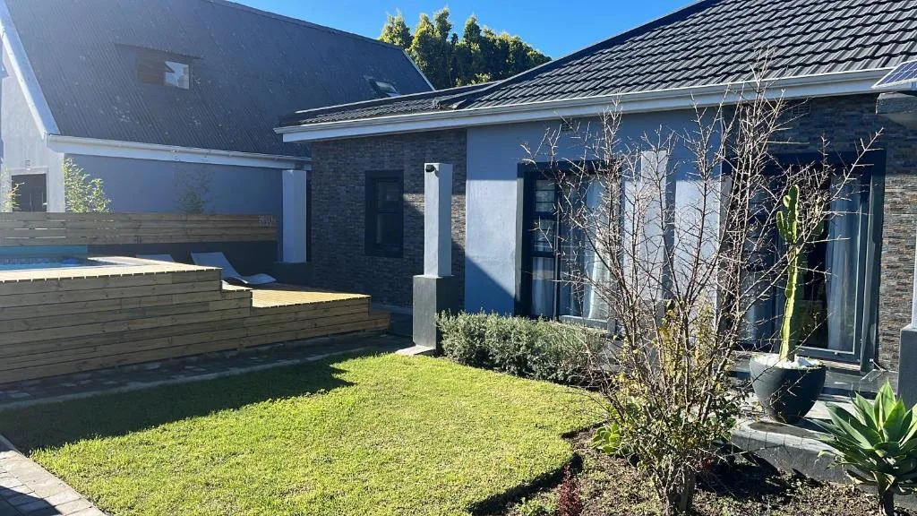 Modern brick house with manicured lawn and landscaping, bright daylight