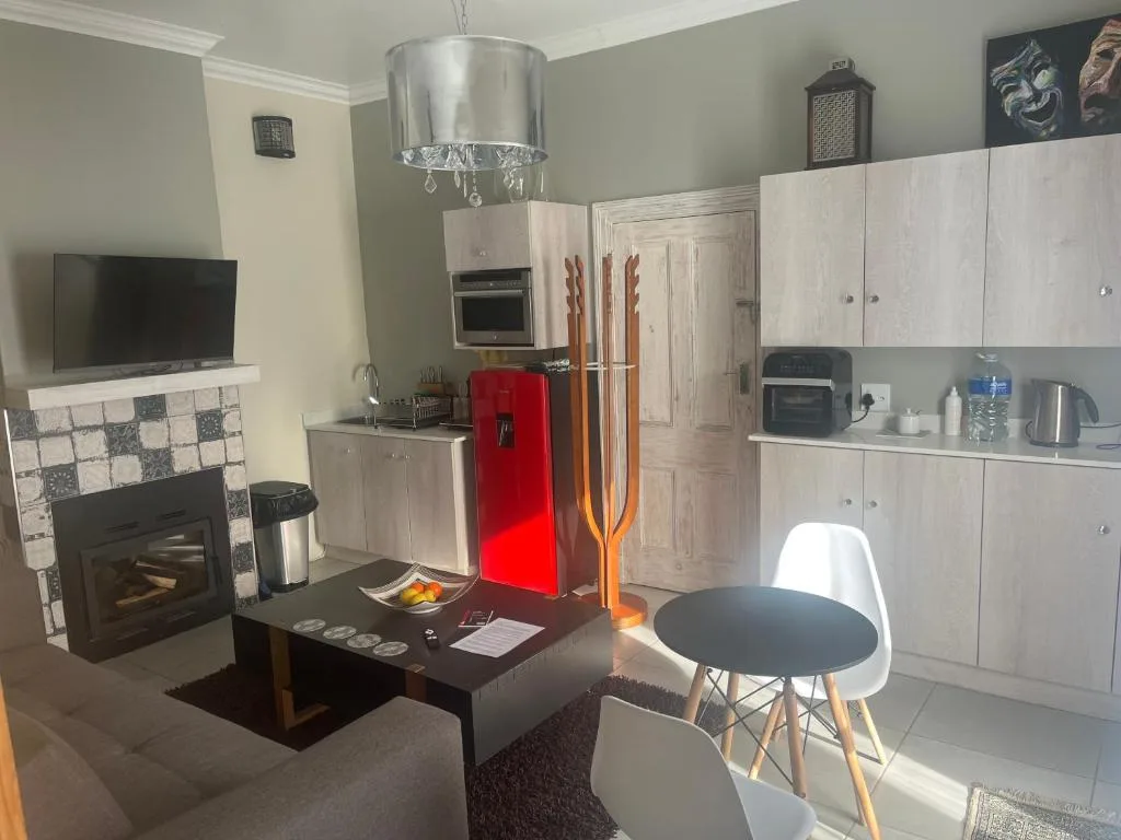 Modern lounge with fireplace, TV, and open-plan kitchen area