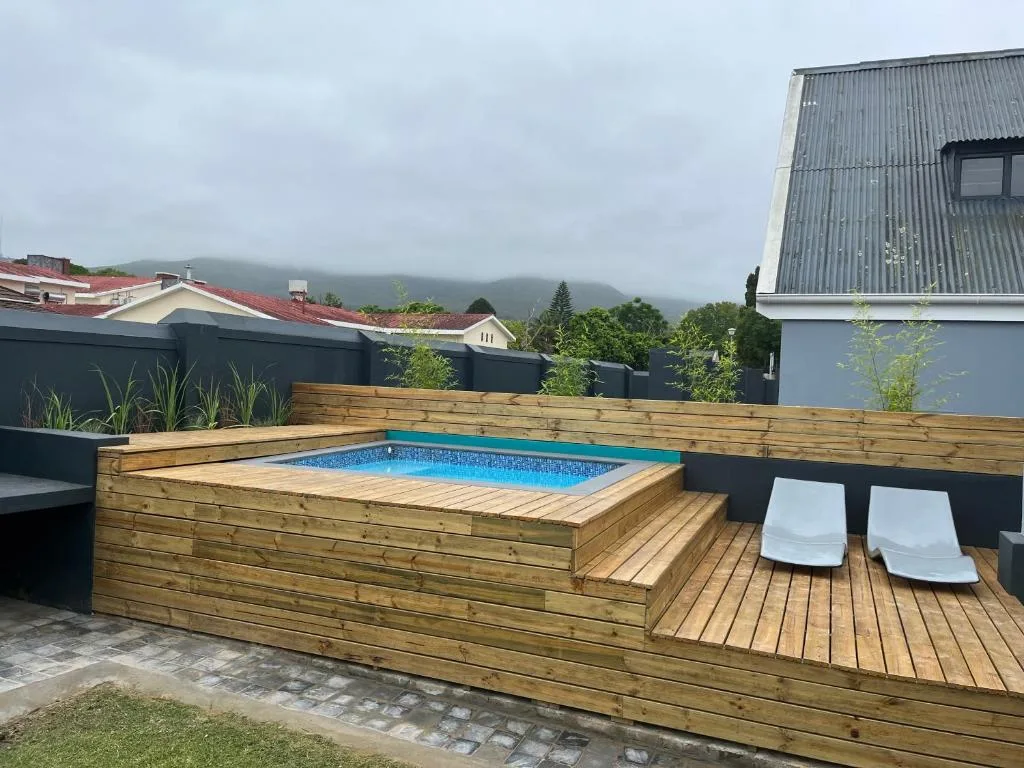 Wooden deck with built-in swimming pool overlooking misty mountains