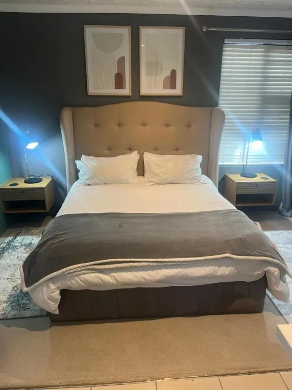 Modern bedroom with upholstered headboard, crisp white linens, and side tables