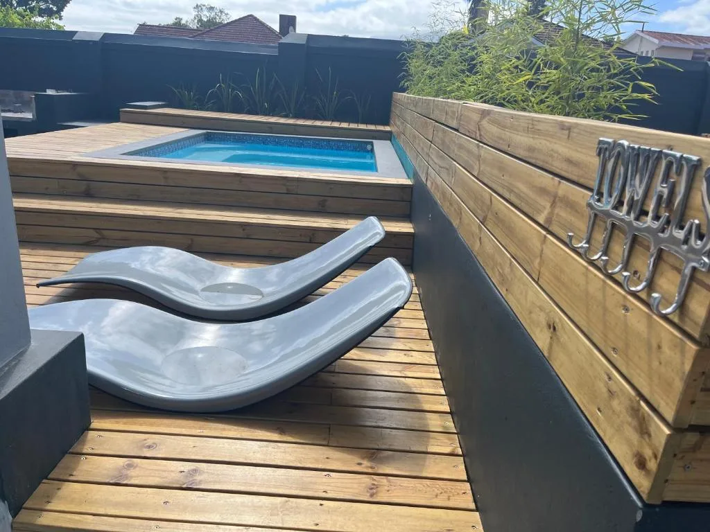 Modern wooden deck with lounge chairs and elevated swimming pool