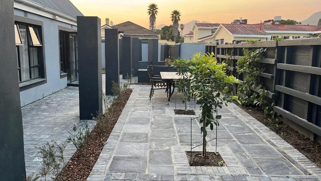 Modern paved patio with seating area and young planted trees