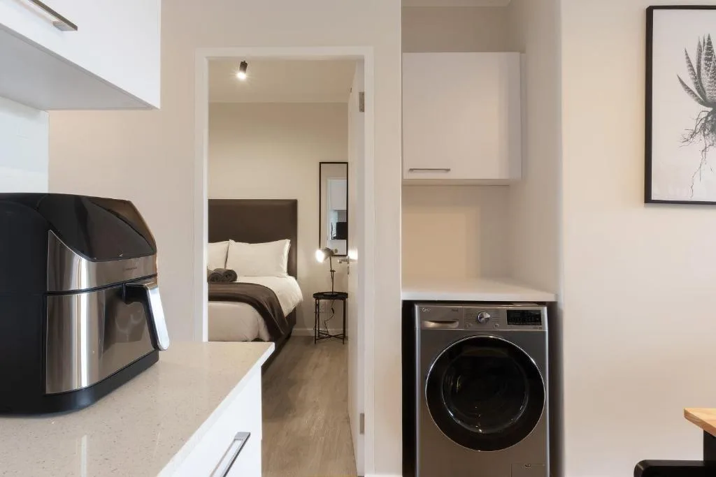 Modern kitchen with stainless steel appliances and view into bedroom