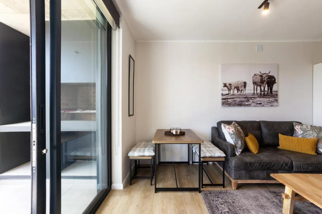 Modern lounge with dark sofa, dining table, and sliding glass doors