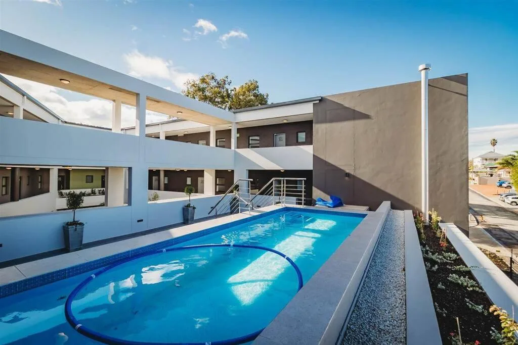 Bright blue swimming pool with modern architectural building courtyard