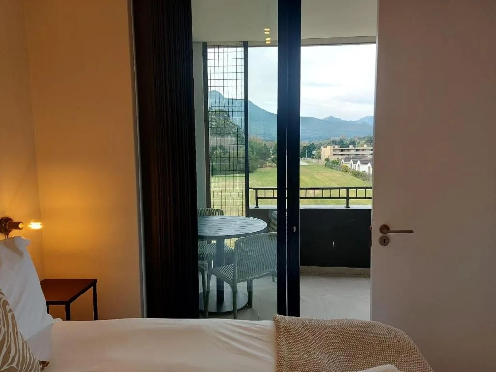 Bedroom with mountain views through glass doors opening onto a deck