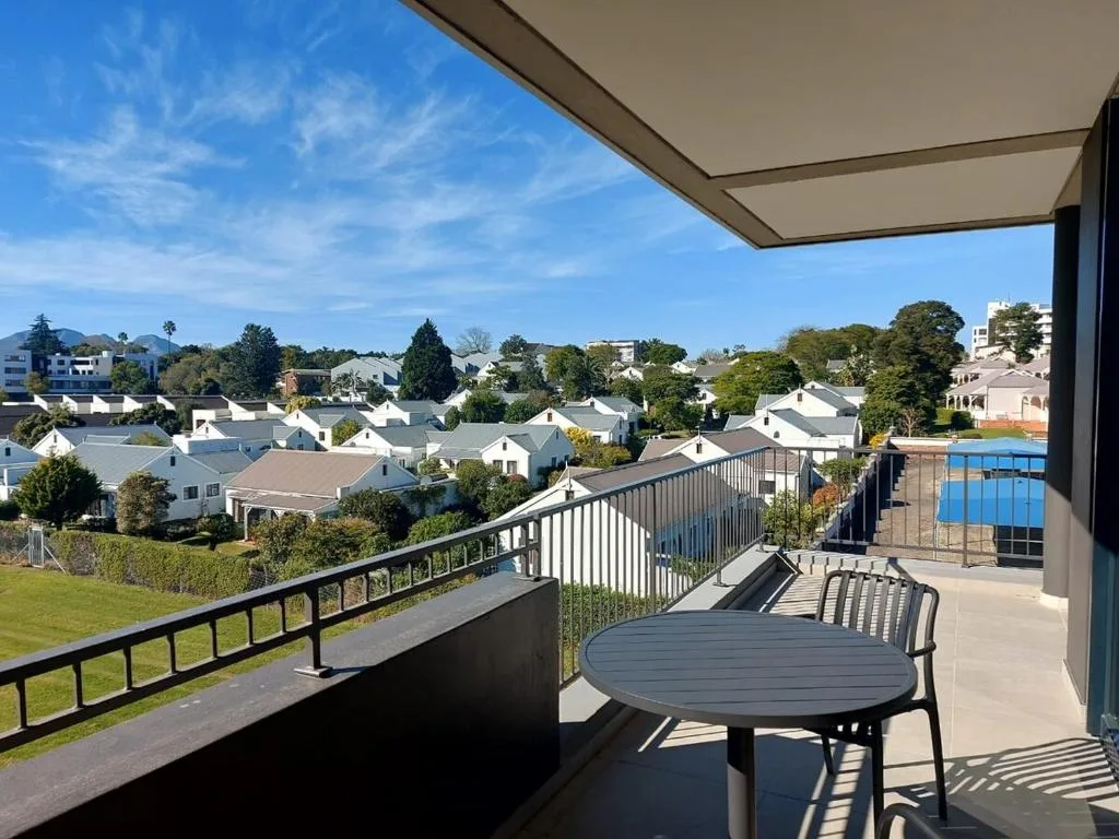 Spacious elevated deck with dining table overlooking George suburb and pool area