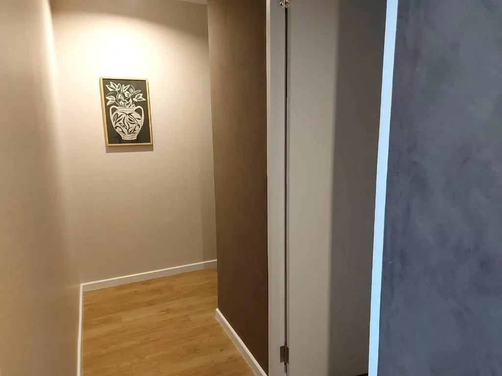 Hallway with floral artwork and wooden flooring in modern apartment