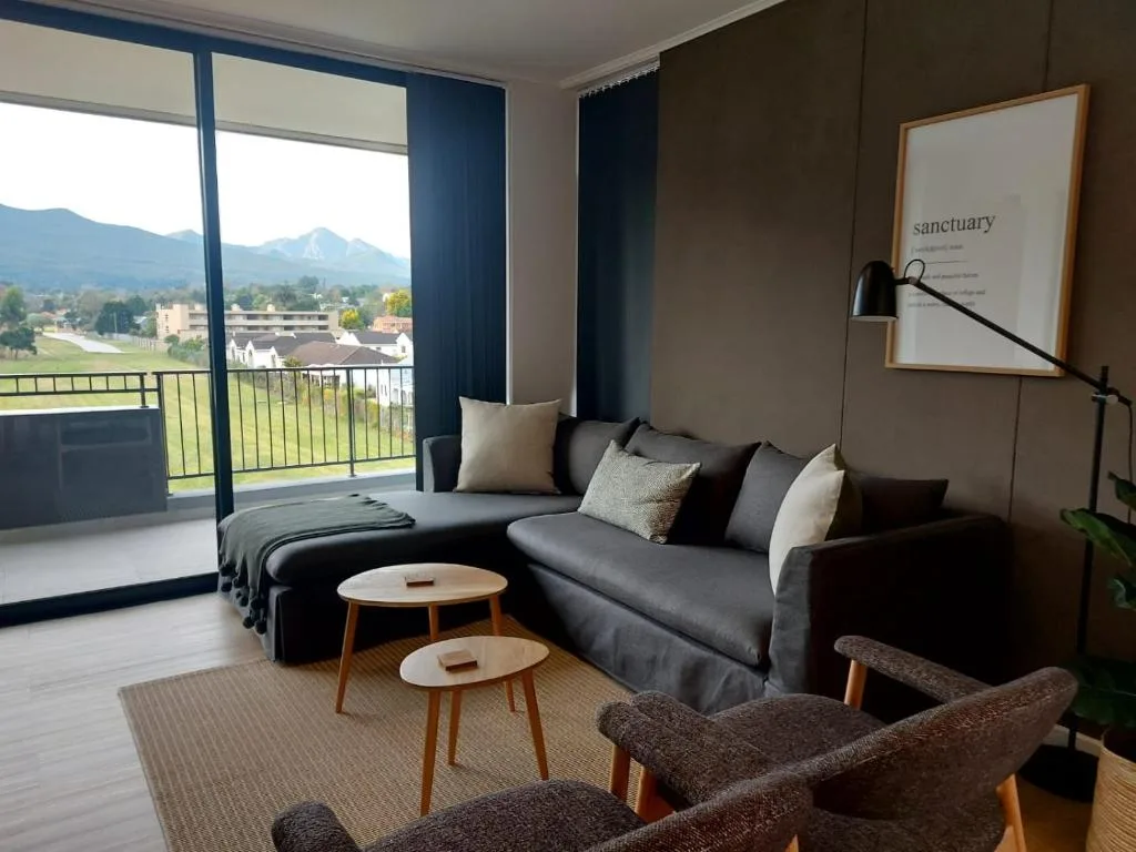 Modern lounge with gray sectional sofa, mountain views through glass doors