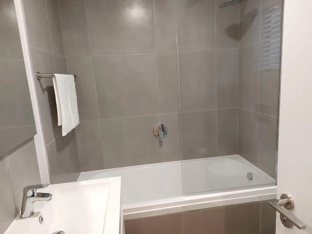 Modern bathroom with tiled shower enclosure and white basin vanity
