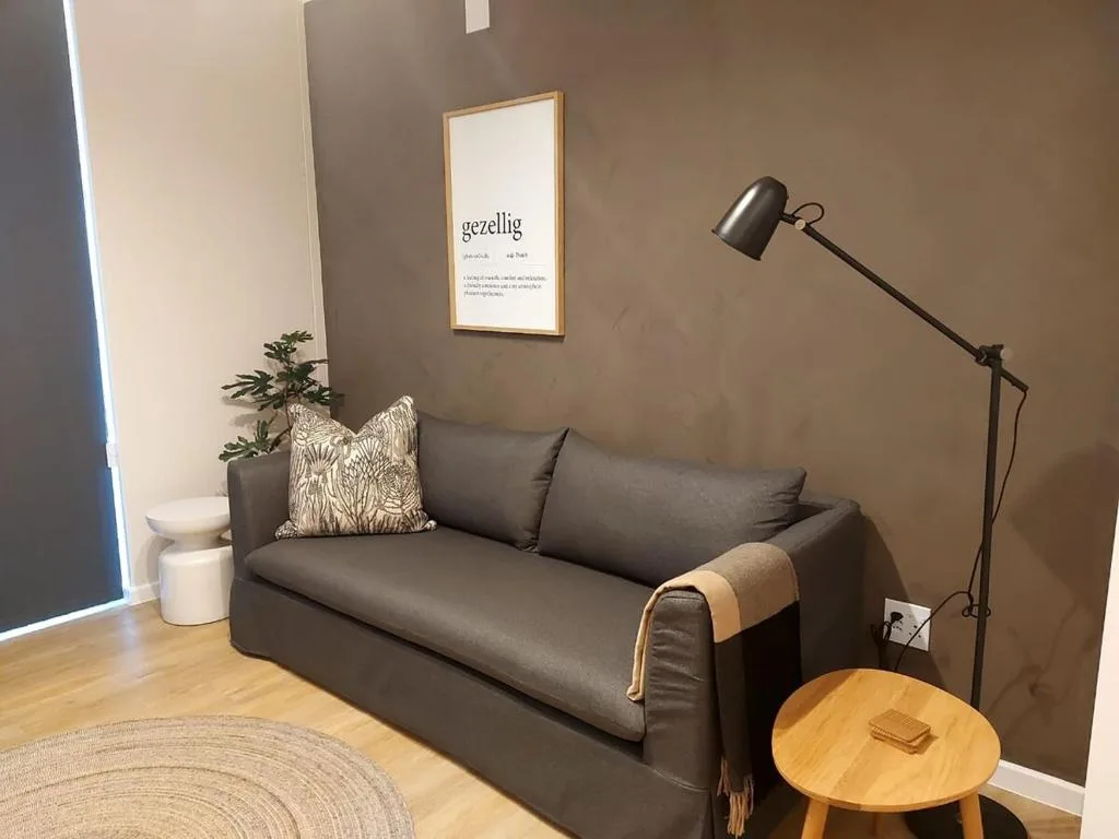 Modern lounge with dark sofa, wooden side table, and minimalist wall art