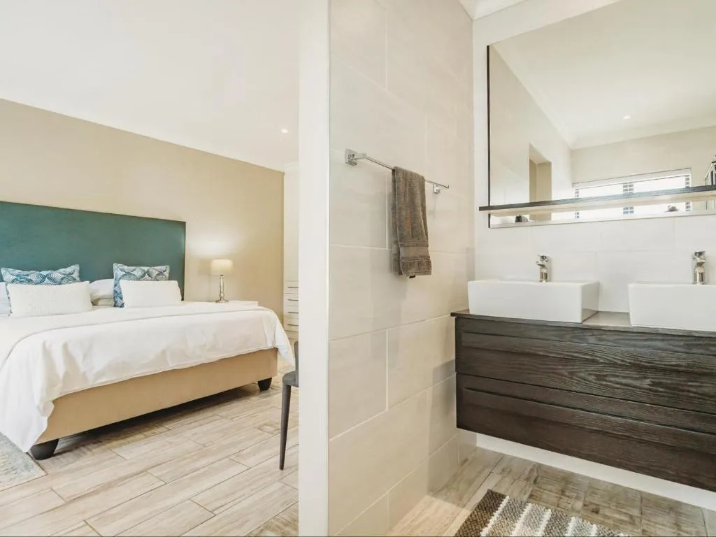 Modern ensuite bathroom with dual vessel sinks and dark wood vanity