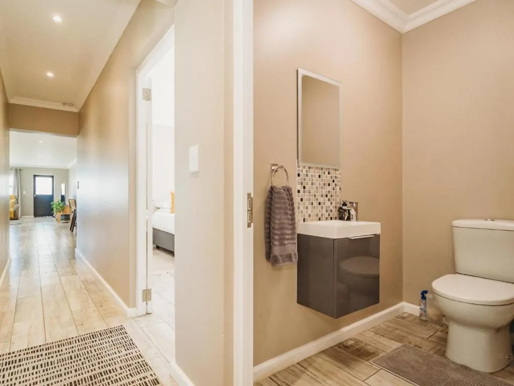 Modern bathroom with dark vanity, mirror, and white toilet fixtures