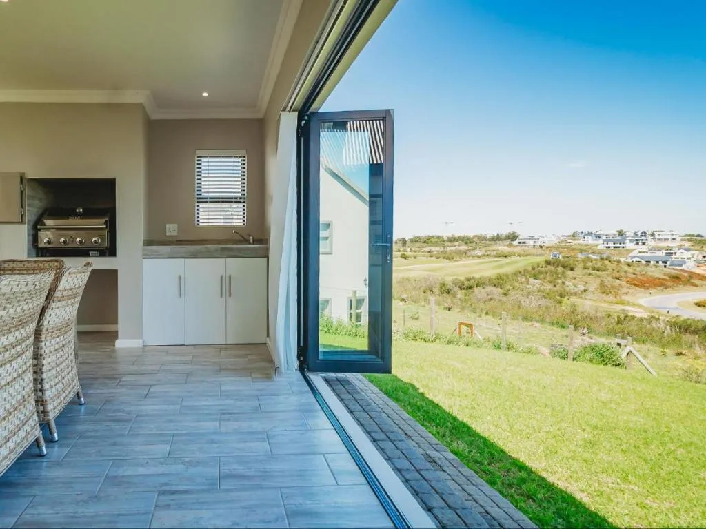 Open sliding door onto tiled patio with countryside views beyond