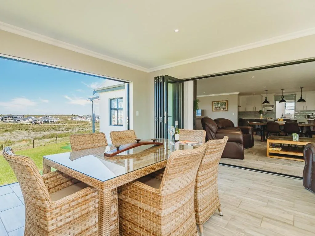 Outdoor patio with wicker dining table overlooking scenic garden landscape
