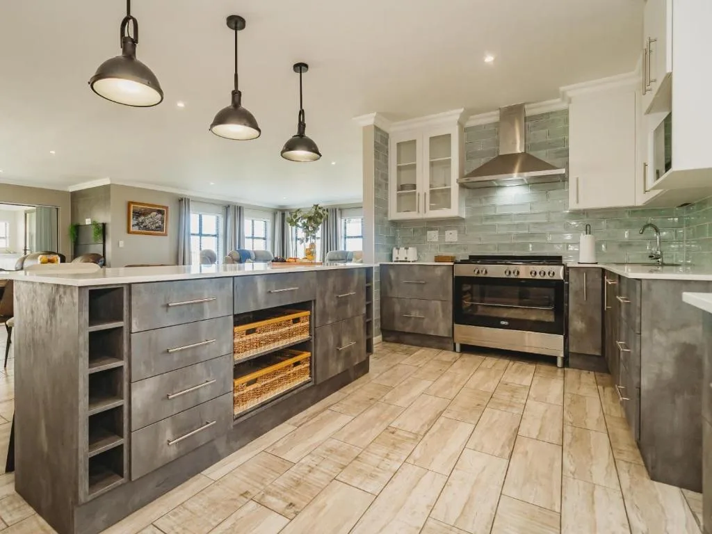 Modern kitchen with dark cabinetry, stainless steel appliances, and pendant lighting