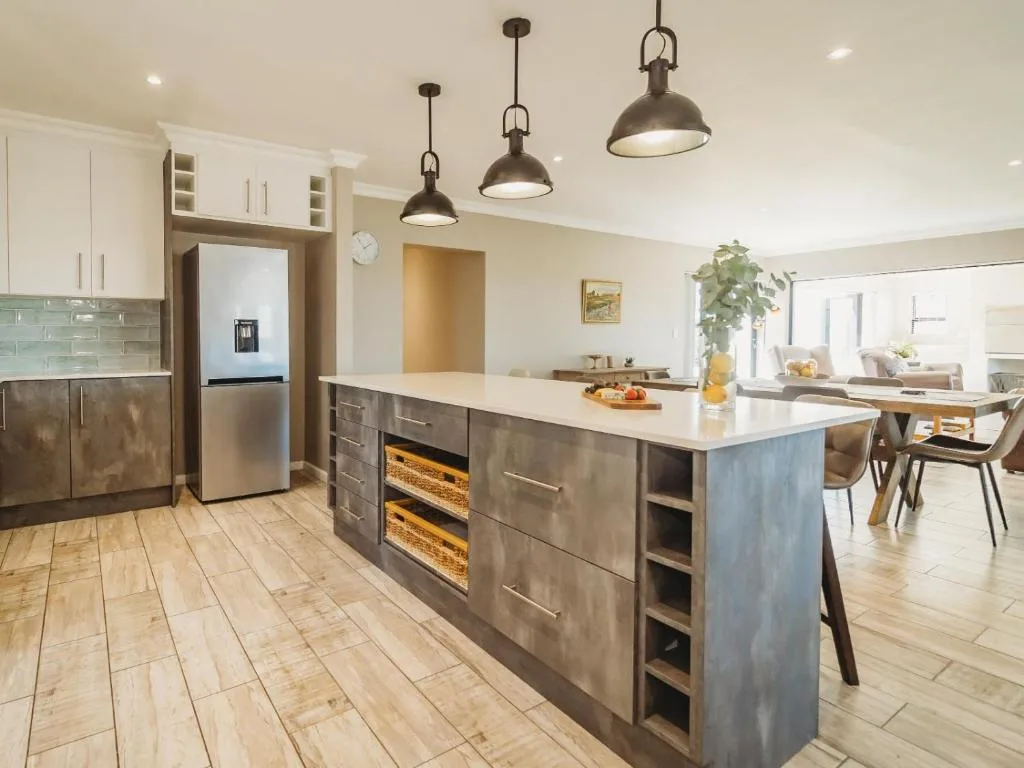 Modern kitchen with island, stainless steel appliances, pendant lights