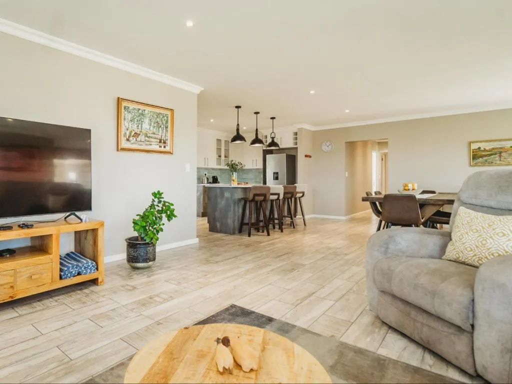 Spacious open-plan lounge with comfortable gray sofa and entertainment area