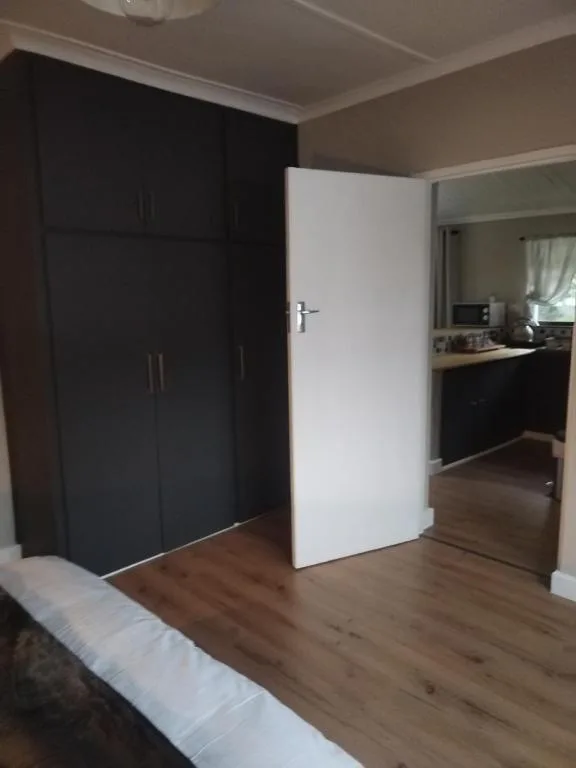 Spacious bedroom with black built-in wardrobe and wooden flooring