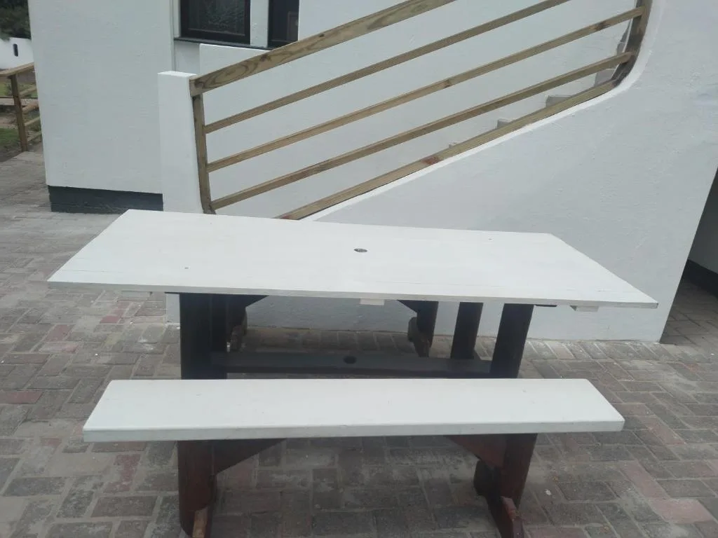 Outdoor picnic table and wooden railing on paved patio area