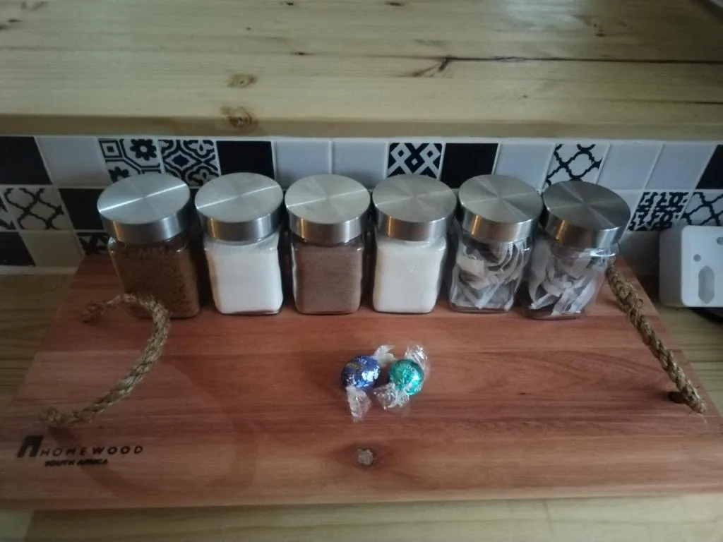 Wooden tray with metal storage containers and decorative items on kitchen counter