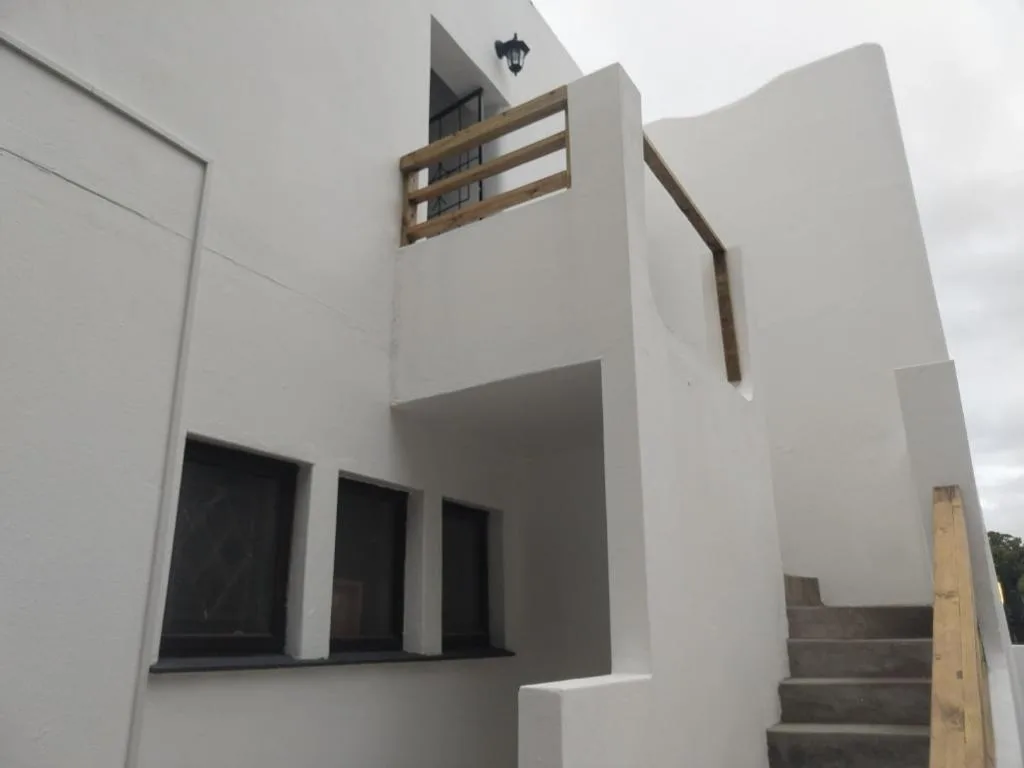 Modern white apartment building facade with wooden balcony railing
