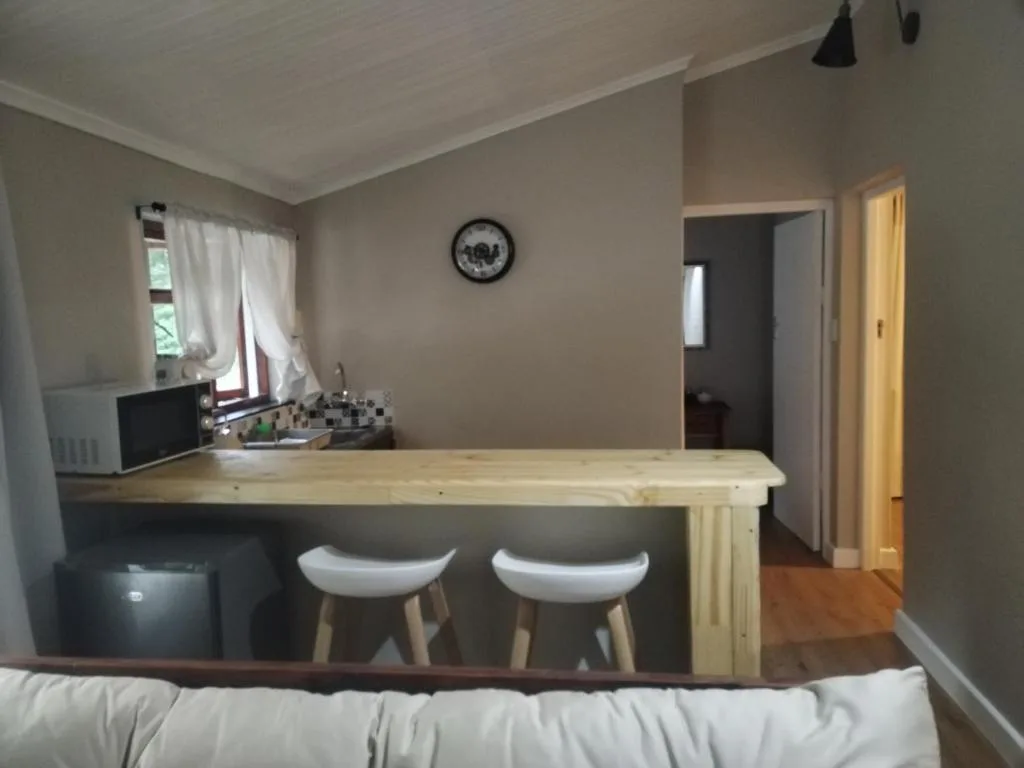 Open-plan lounge with kitchen counter and white bar stools