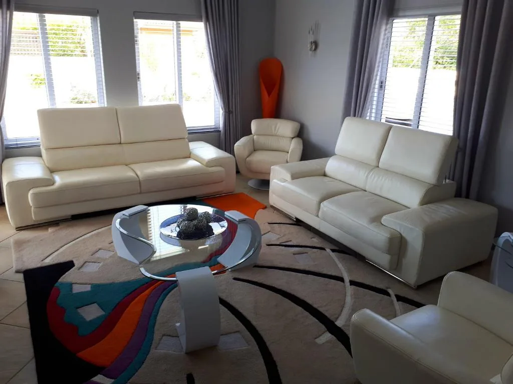 Bright modern lounge with cream leather sofas and contemporary glass table