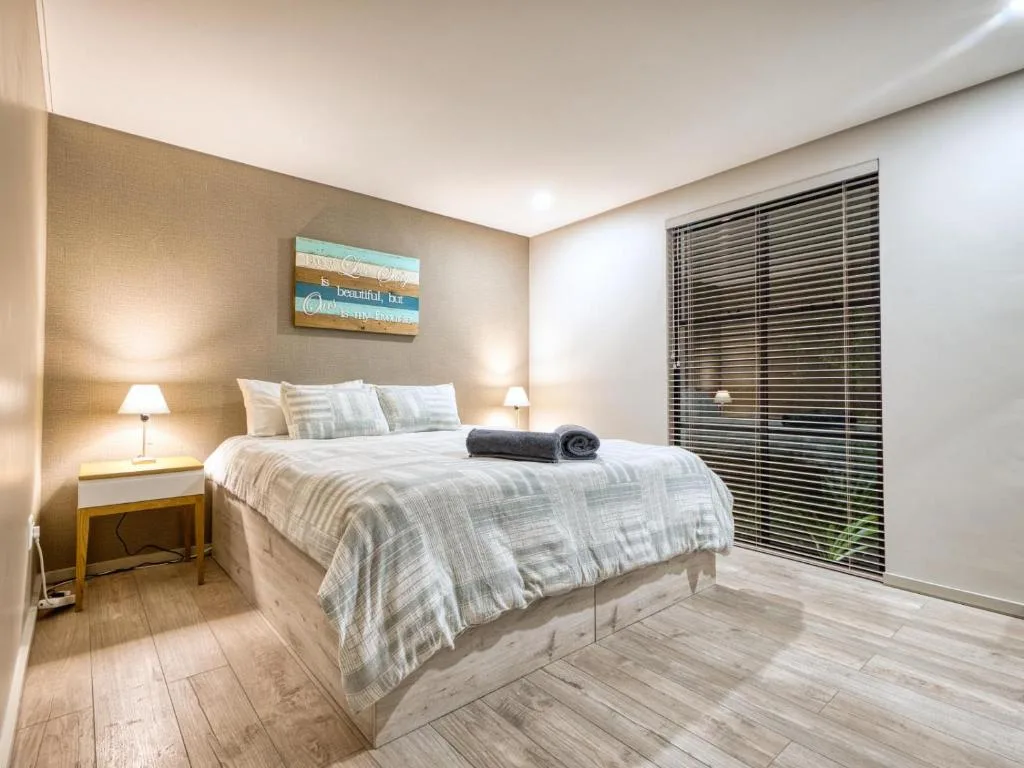 Modern bedroom with queen bed, side table lamps, and built-in wardrobe