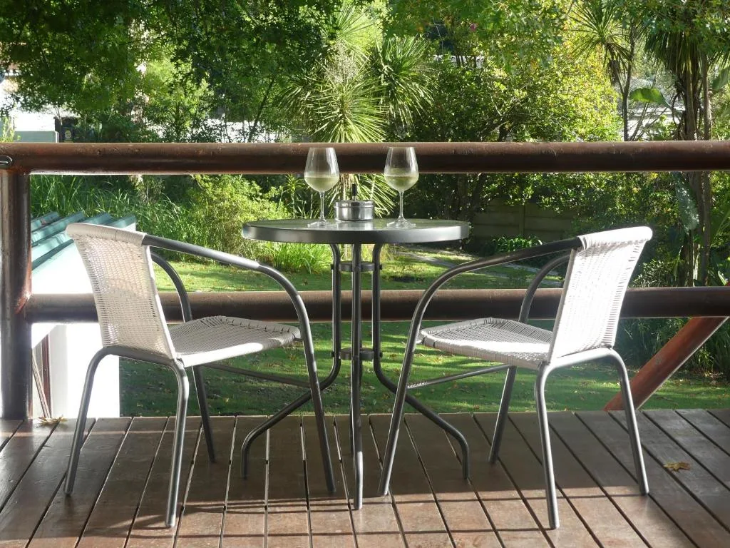 Shaded outdoor dining area with table, chairs, and garden views