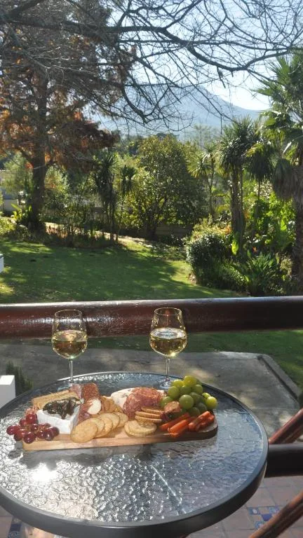 Garden view from balcony with charcuterie board and wine glasses
