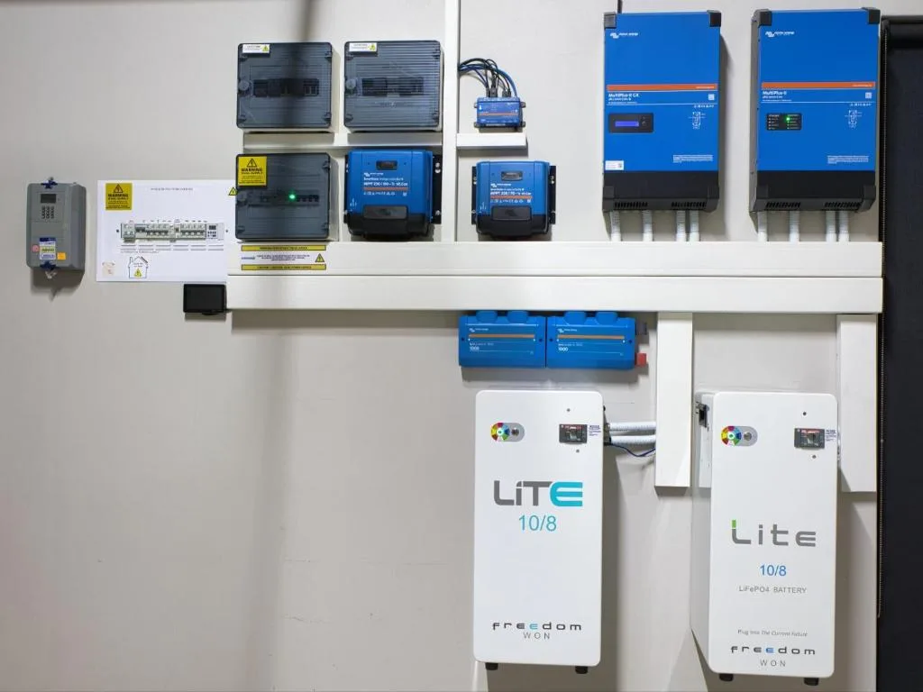 Solar battery system and electrical inverters mounted on white wall panel