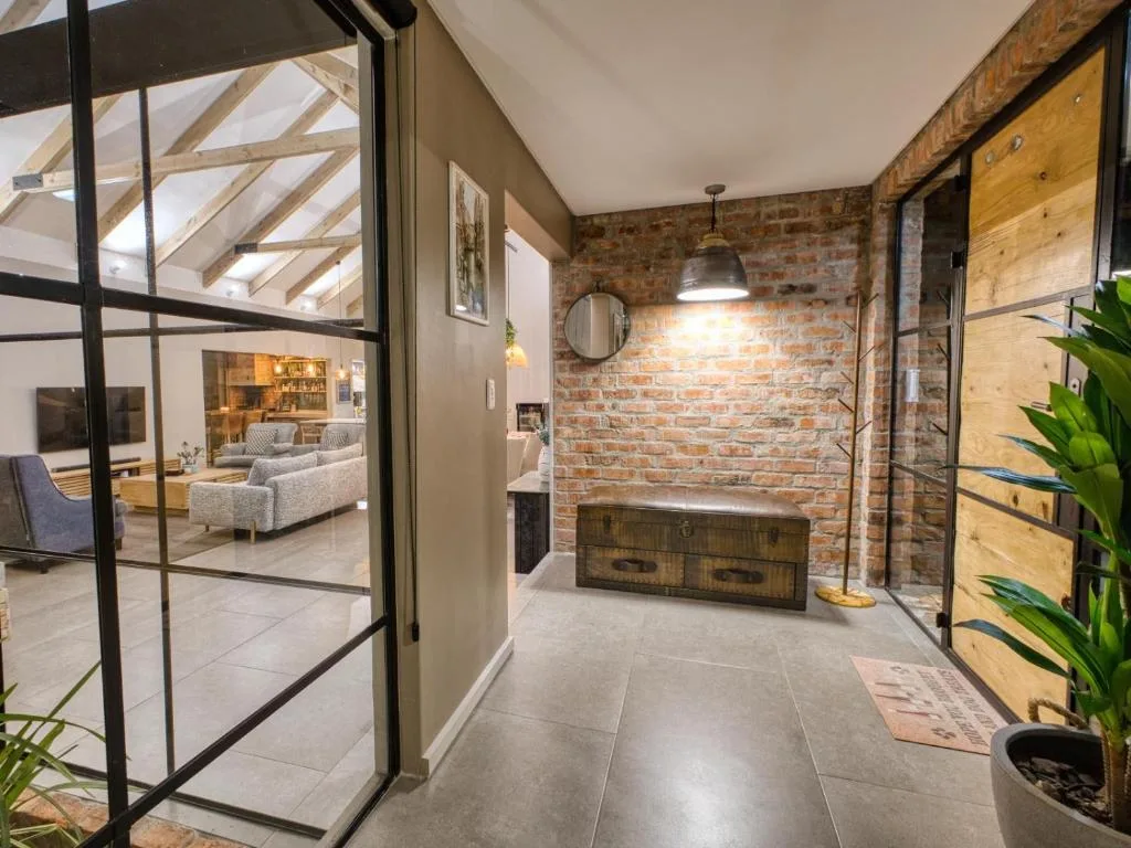 Modern hallway with exposed brick wall and vintage wooden trunk storage