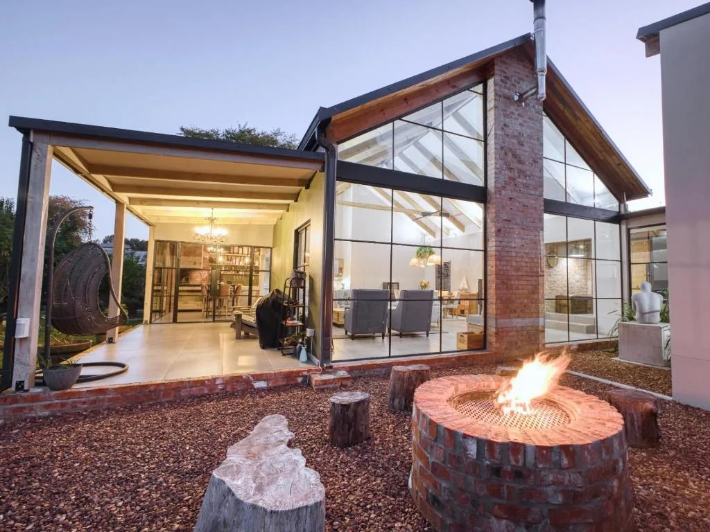 Modern brick and glass home exterior with firepit and lounge seating area