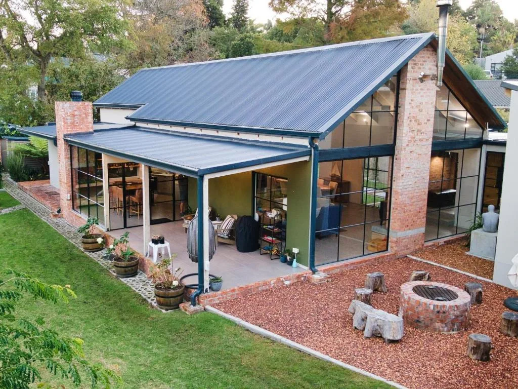 Modern brick and steel home with covered deck and manicured gardens