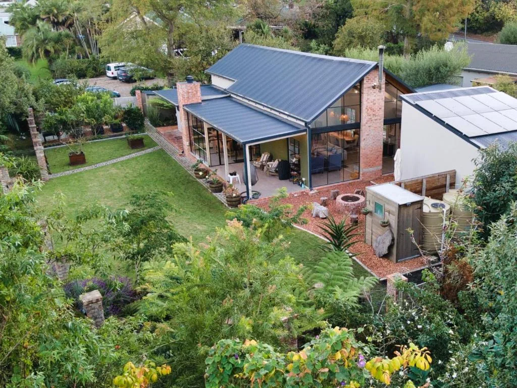 Modern brick and steel home with manicured gardens and mature trees