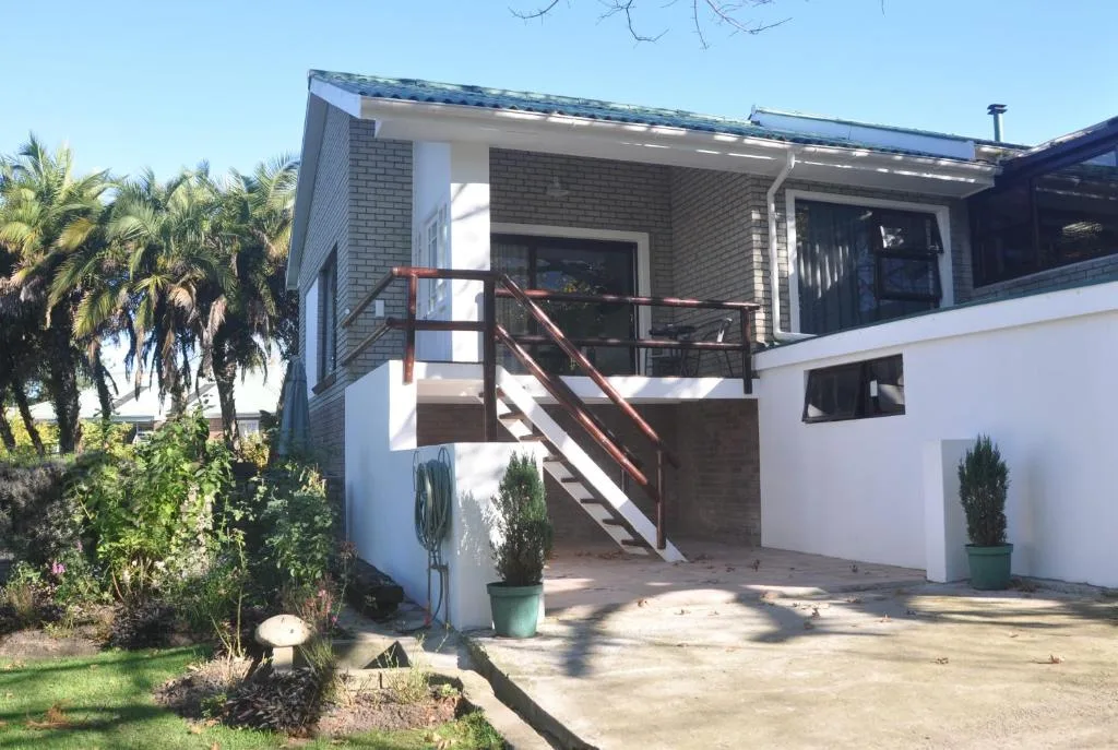 Modern brick and white rendered house with metal staircase and deck entrance