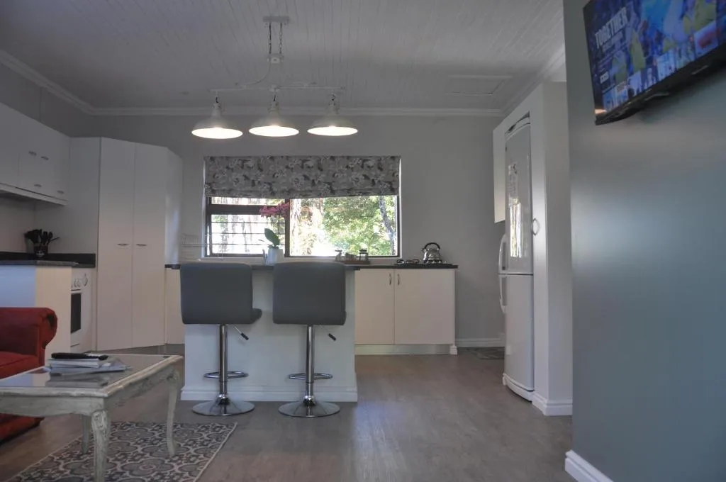 Modern open-plan kitchen with white cabinetry, island seating, and pendant lighting