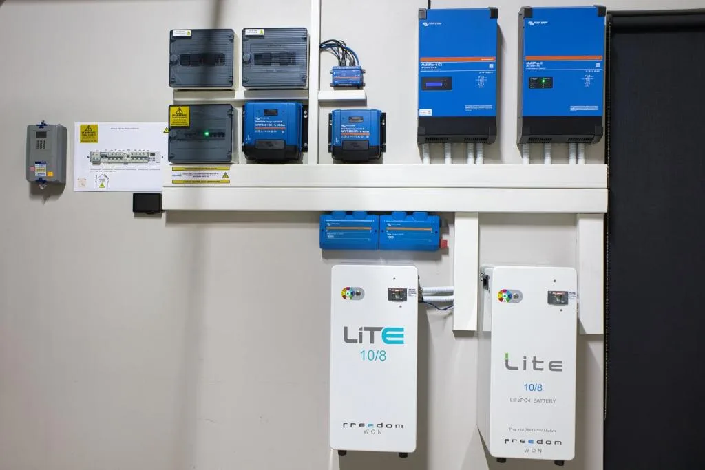 Solar power system components including inverters and battery units mounted on wall