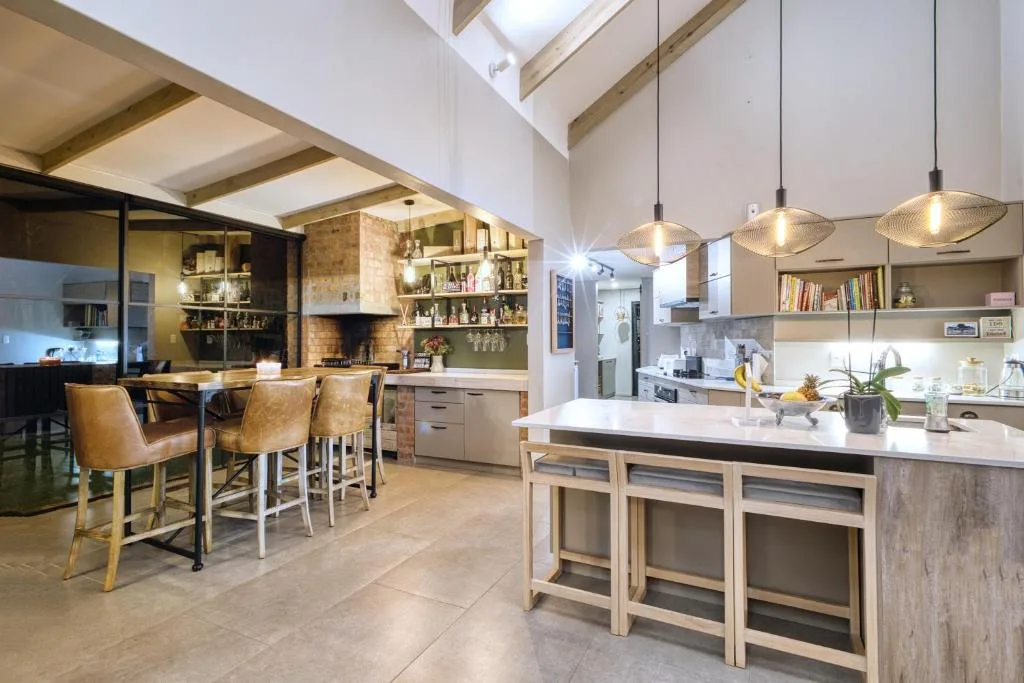 Modern open-plan kitchen with island, pendant lights, and brick fireplace