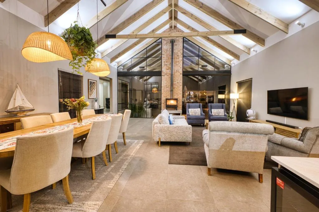 Open-plan lounge with sofas, dining table, and modern fireplace